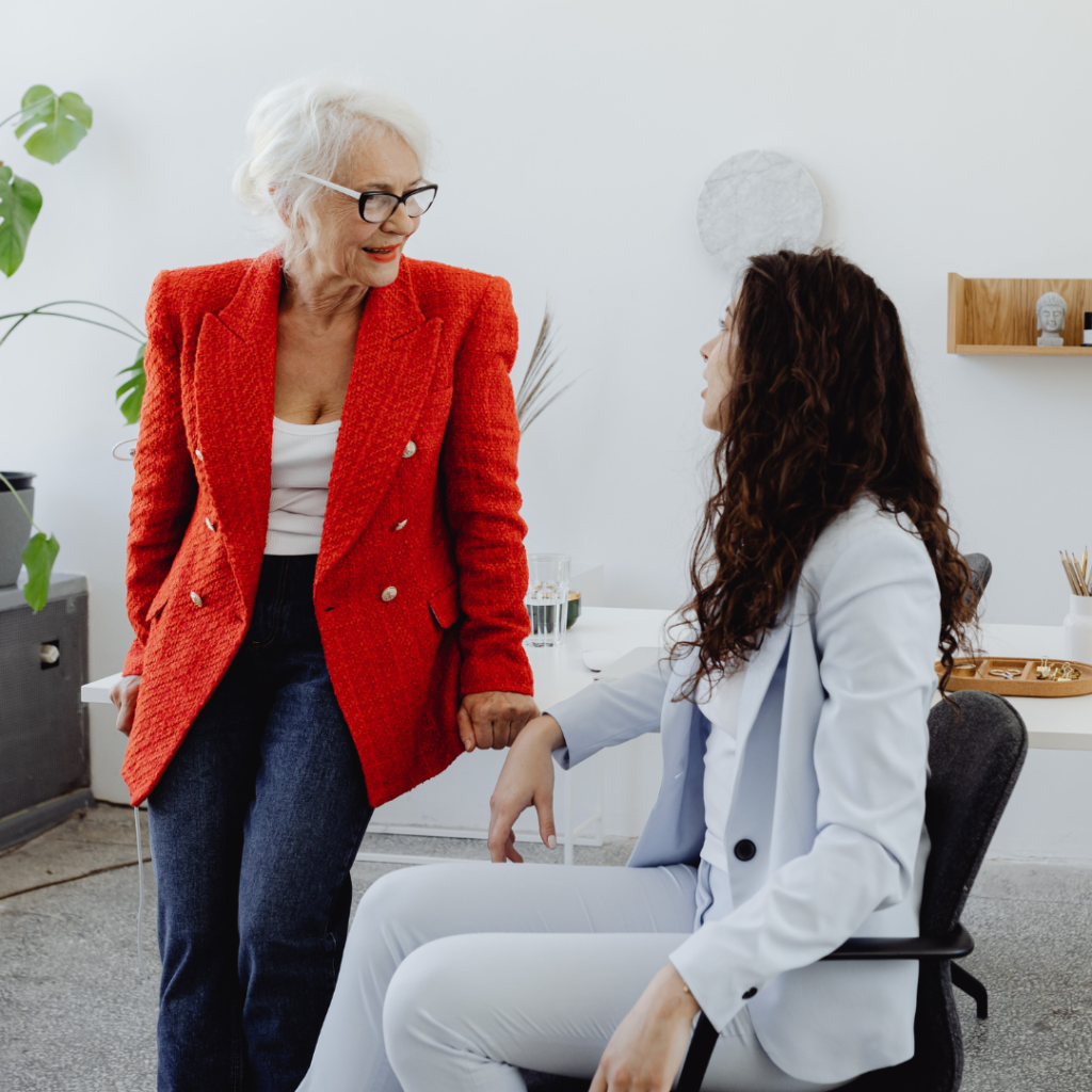 Two women sit at a desk, an example of collective leadership